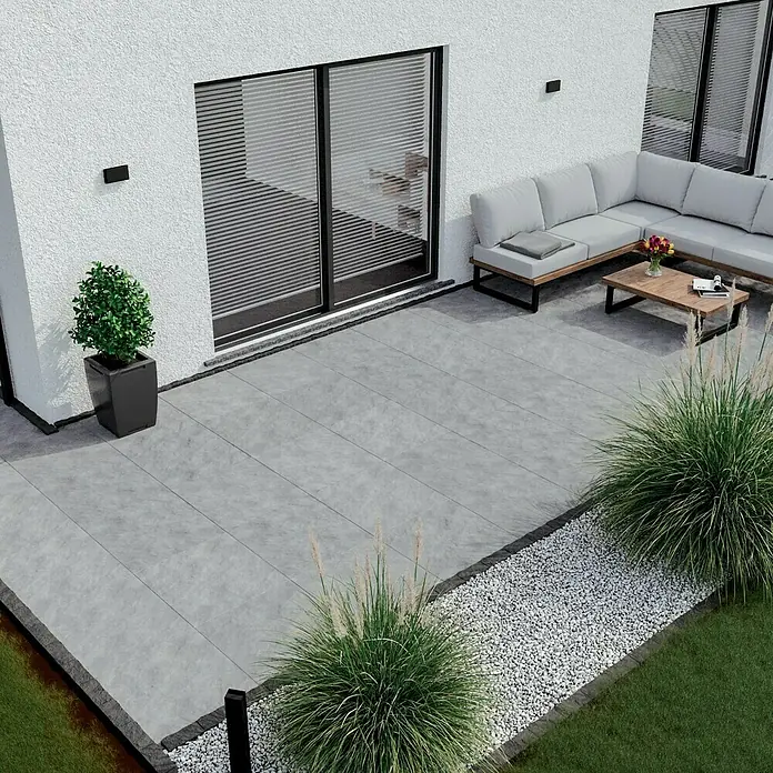 Terrassenfliese Atakama - 59,3 x 59,3 x 2 cm, Hellgrau, Matt - Eine moderne Terrasse mit grauen Fliesen, die nahtlos mit dem Haus verbunden ist, bietet einen stilvollen Außenbereich mit Sitzmöbeln.