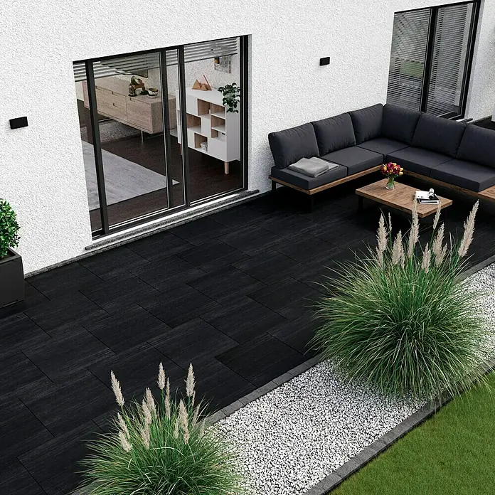 Terrassenfliese Garden Black Struktur - 59,7 x 59,7 x 2 cm, Schwarz, Matt - Terrassenbild mit schwarzen Steinplatten, die einen modernen und eleganten Außenbereich schaffen, ergänzt durch eine stilvolle Lounge und dekorative Bepflanzung.