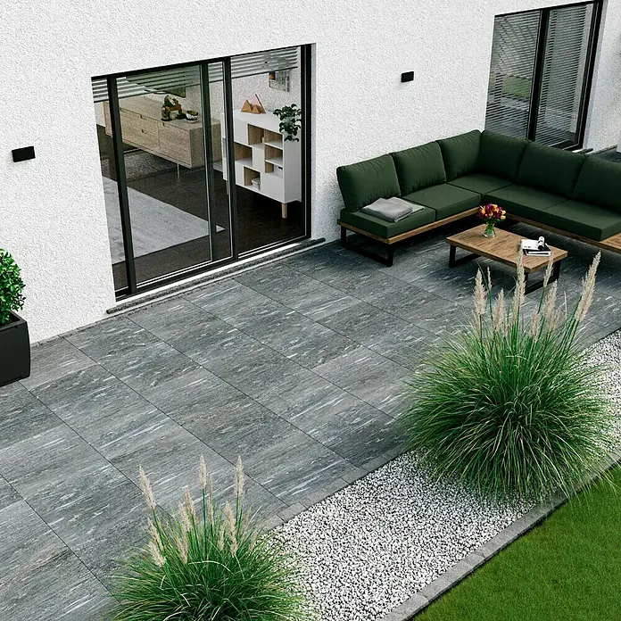 Marazzi Terrassenfliese Esterno 20T Davos - 60 x 60 x 2 cm, Grau, Matt - Bild einer grauen Terrassenfliese im Außenbereich mit moderner Sitzgruppe und dekorativen Gräsern.