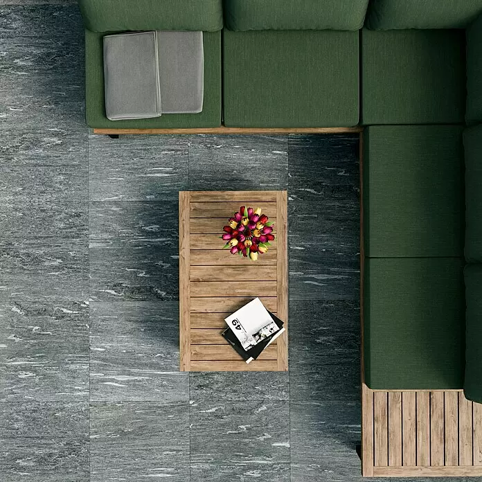 Marazzi Terrassenfliese Esterno 20T Davos - 60 x 60 x 2 cm, Grau, Matt - Draufsicht auf ein grünes Ecksofa mit Holzrahmen und einen Holztisch auf grau gefliestem Patio.