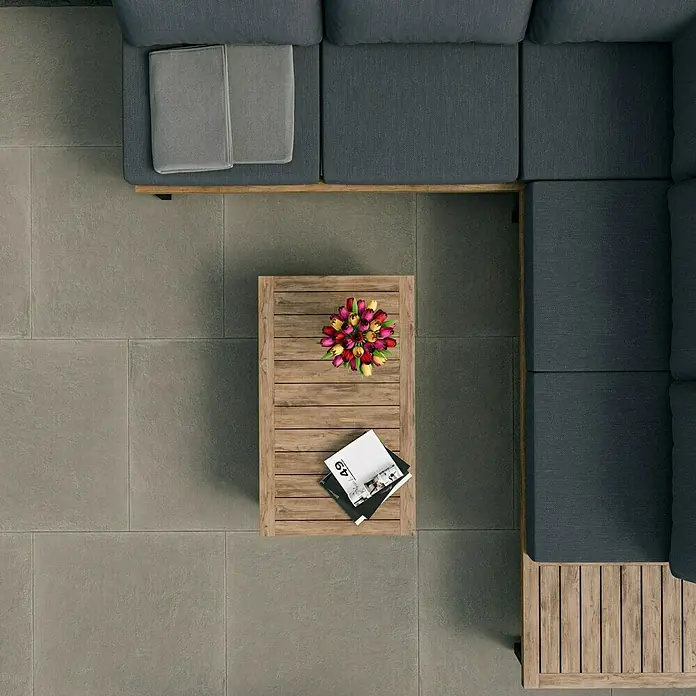 Marazzi Terrassenfliese Esterno 20T Material80 x 80 x 2 cm, Grau, Matt - Draufsicht auf eine stilvolle Außensitzgruppe mit einem Holztisch, Blumen und Magazinen auf einer grauen Terrasse.