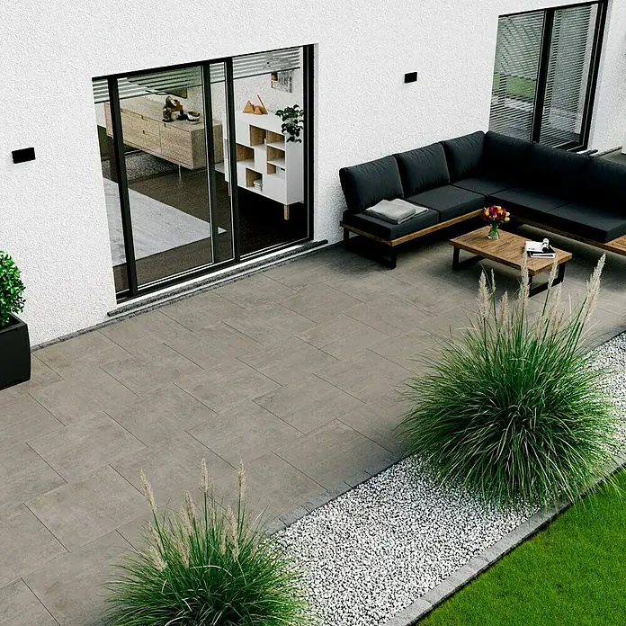 Terrassenfliese Garden Grey - 60 x 60 x 2 cm, Grau, Matt - Moderne Terrassengestaltung mit grauen Terrassenplatten, stilvoller Lounge-Ecke und dekorativen Ziergräsern für eine entspannte Atmosphäre im Freien.