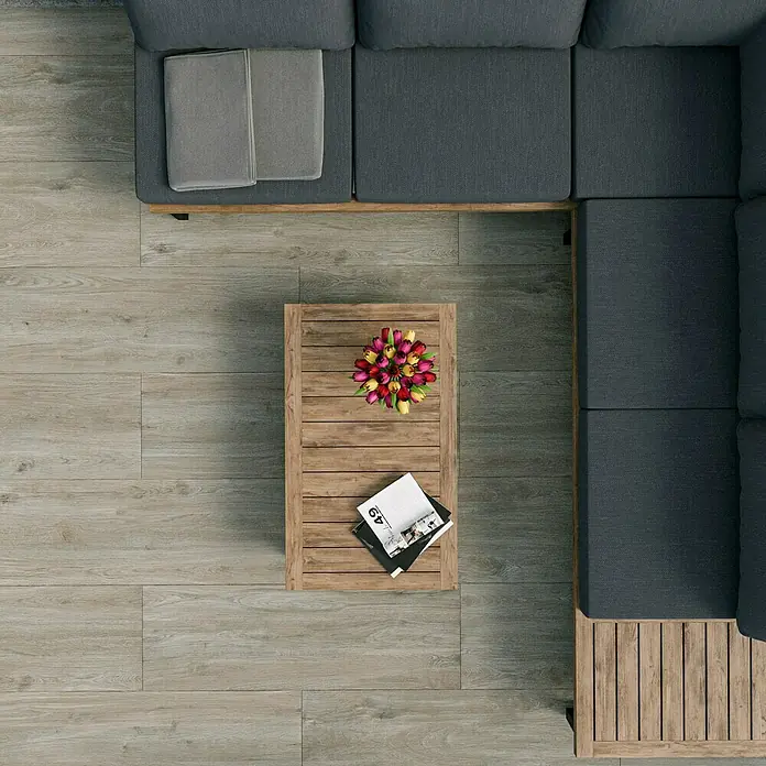 Marazzi Terrassenfliese Esterno 20T Woodliving Fumo - 40 x 120 x 2 cm, Beige, Matt - Draufsicht auf ein Wohnzimmer mit modularem Ecksofa, Holztisch mit Blumen und Magazinen auf einem Holzboden.