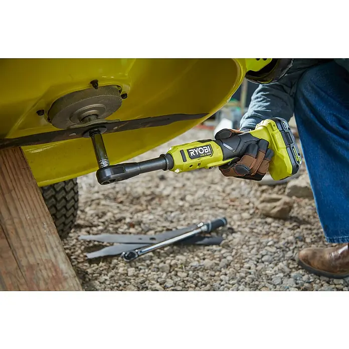Ryobi ONE+HP Akku-Ratschenschrauber RRW1838X-0 - 18 V, Ohne Akku, ⅜″ Vierkant, 75 Nm - Ein gelber Ryobi-Schlagschrauber wird verwendet, um die Klinge eines Rasenmähers zu wechseln.