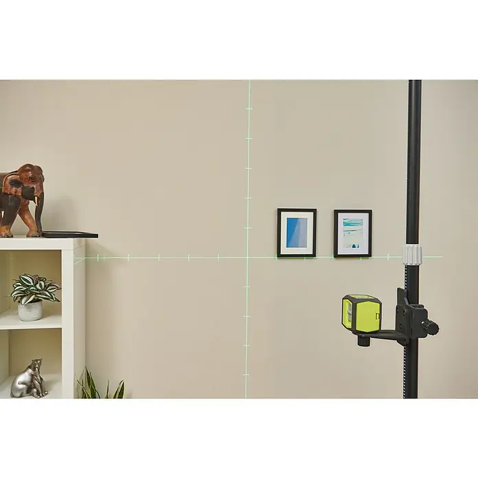 Ryobi Kreuzlinienlaser RBCLLG2 mit Skalamarkierung - Max. Arbeitsbereich: 15 m - Bild zeigt einen grünen Linienlaser, der an einer schwarzen Stange befestigt ist und horizontale sowie vertikale Linien an die Wand projiziert.