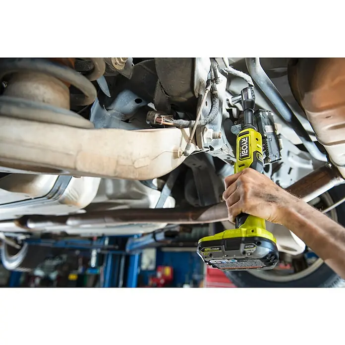 Ryobi ONE+HP Akku-Ratschenschrauber RRW1838X-0 - 18 V, Ohne Akku, ⅜″ Vierkant, 75 Nm - Nahaufnahme eines Ryobi ONE+ Akku-Ratschenschraubers, der unter einem Auto verwendet wird, ideal für Reparaturen und Wartung.