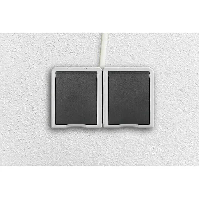 Aqua Form Feuchtraum-Steckdose - Anthrazit, 2-fach, Ausrichtung Schalterprogramm: Horizontal, Aufputzmontage, IP44 - Doppelte graue Lichtschalter mit weißen Rahmen an einer weißen Wand.