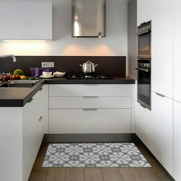 Alfombra de vinilo Croma BCN - Gris, 110 x 50 cm - Primer plano de una cocina moderna con una alfombra decorativa gris, armarios blancos y una campana extractora de acero.