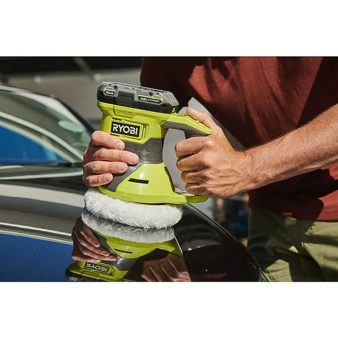 Ryobi ONE+ Akku-Poliermaschine RBP18150-0 - Ohne Akku, Leerlaufdrehzahl: 1.500 U/min - 4.500 U/min - Nahaufnahme eines Mannes, der ein Auto mit einem RYOBI-Polierer mit Akku poliert.