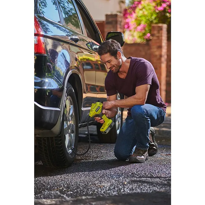 Ryobi ONE+ Akku-Kompressor R18PI-0 - 18 V, Li-Ionen, Ohne Akku - Ein Mann befüllt einen Autoreifen mit einem gelben RYOBI-Inflator. Der RYOBI-Inflator pumpt Reifen schnell und einfach auf.