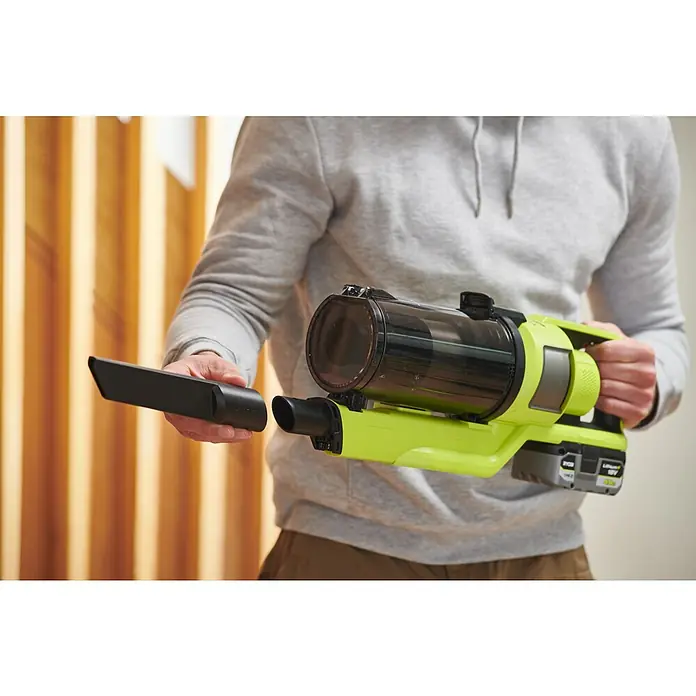 Ryobi ONE+HP Akku-Staubsauger RSV18X1-018 V, Ohne Akku, Behältervolumen: 0,8 l - Nahaufnahme eines Mannes, der einen grünen Ryobi Akku-Handsauger mit einem schwarzen Aufsatz in der Hand hält.