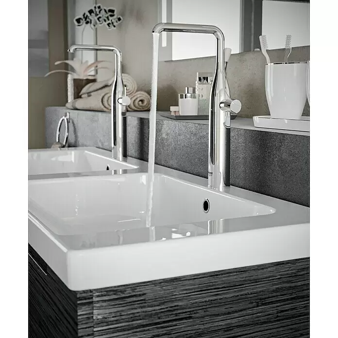 Grohe Essence Waschtischarmatur XL-Size - Chrom, Glänzend - Modernes Doppelwaschbecken mit Chromarmaturen, eine läuft Wasser, auf einer dunkelgrauen strukturierten Waschtischplatte.
