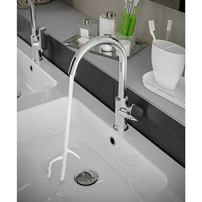 Hansgrohe Logis Waschtischarmatur 210 - Chrom, Glänzend - Nahaufnahme eines modernen Badezimmers mit Doppelwaschbecken und verchromten Wasserhähnen, aus denen Wasser fließt. Die stilvolle Einrichtung wirkt elegant.