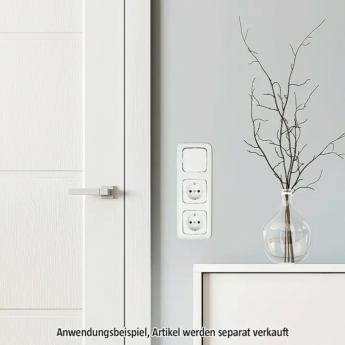 Busch-Jaeger Reflex SI Abdeckrahmen 2513-214 - Alpinweiß, 3-fach, Kunststoff - Nahaufnahme einer weißen Steckdosen- und Schalterkombination an einer grauen Wand neben einer Tür.