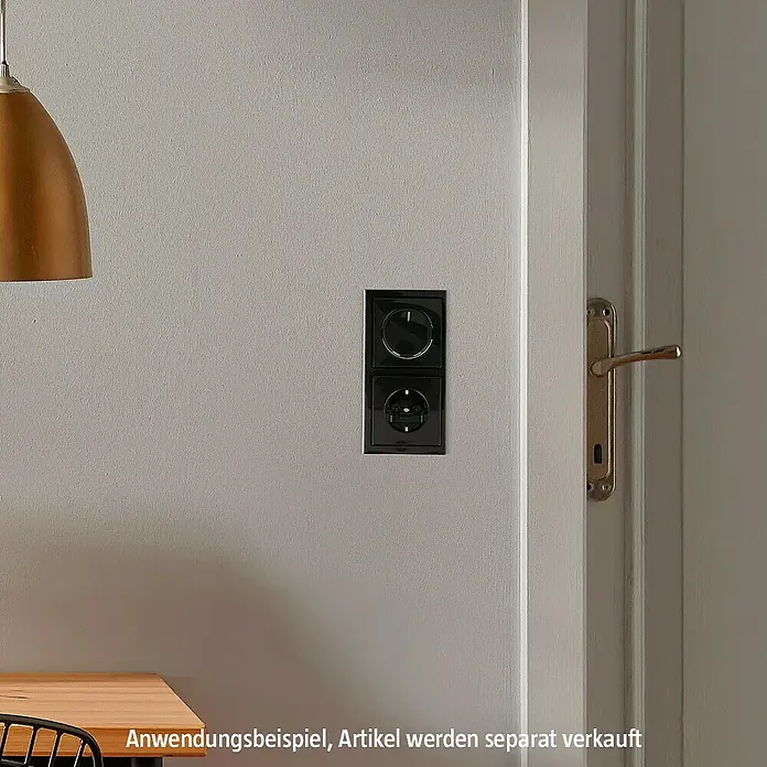 Jung LED-Dimmer 1730 DD - Metall - Ein schwarzer Dimmer und eine Steckdose sind an einer grauen Wand montiert und zeigen ein modernes Design für den Innenbereich.