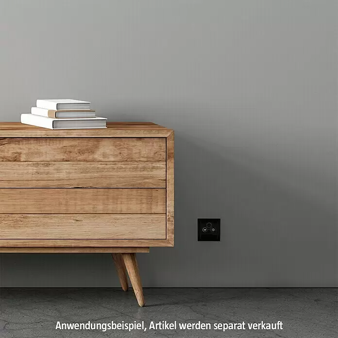 Busch-Jaeger Future Linear Antennenabdeckung 1743-81 - Anthrazit, Glänzend, Kunststoff, Unterputzmontage - Schwarze Wandsteckdose mit zwei runden Anschlüssen, an einer Wand neben einem Holzschrank.