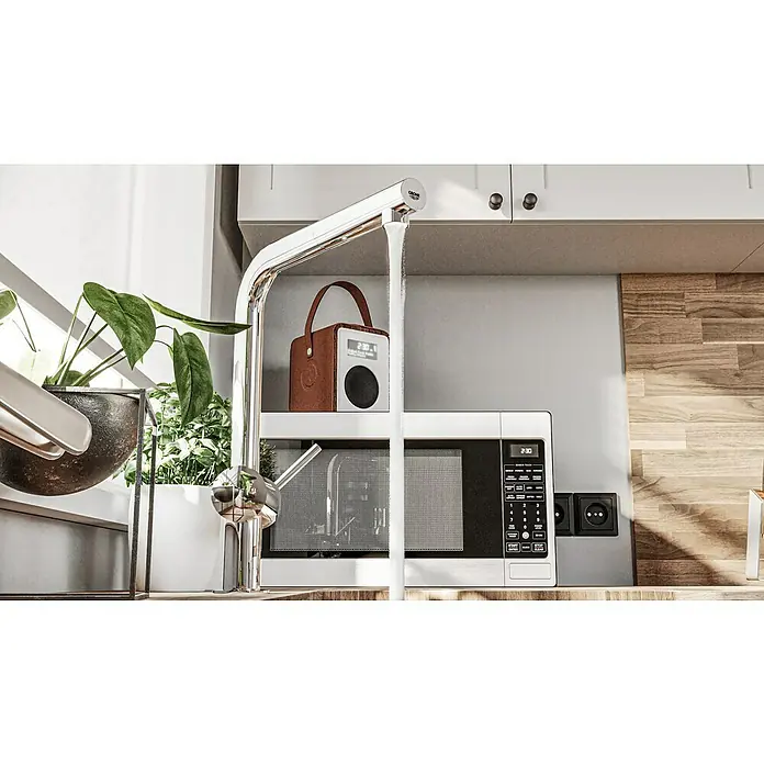 Grohe Spültischarmatur Minta - L-Auslauf, Chrom, Glänzend, Ausziehbar - Nahaufnahme einer modernen Küche mit einem eleganten Chromhahn, der Wasser spendet, einem Radio und einer Mikrowelle.
