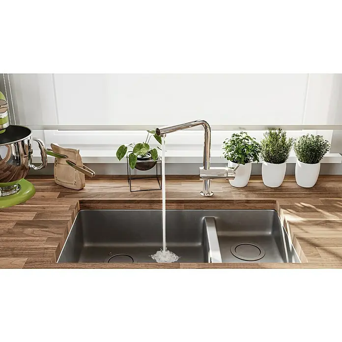 Grohe Spültischarmatur Minta - L-Auslauf, Chrom, Glänzend, Ausziehbar - Küchenspüle aus Edelstahl mit Wasserhahn, umgeben von Holzarbeitsplatten, Kräutern und einer grünen Küchenmaschine.