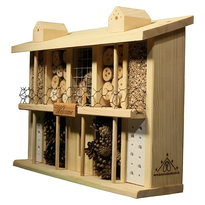 Dobar Insektenhotel Landsitz Superior - 47 x 12,5 x 34 cm, Kiefer - Ein geräumiges Insektenhotel aus hellem Holz mit mehreren Fächern, gefüllt mit Naturmaterialien und einem "Welcome"-Schild.