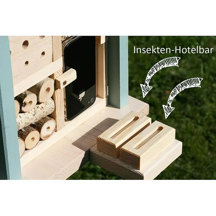 Dobar Insektenhotel Kubus - 27 x 27 x 105 cm, Holz, Grün/Blau - Nahaufnahme eines Insektenhotels mit verschiedenen Füllmaterialien und Unterkünften, darunter Holzscheite und ein Smartphone.