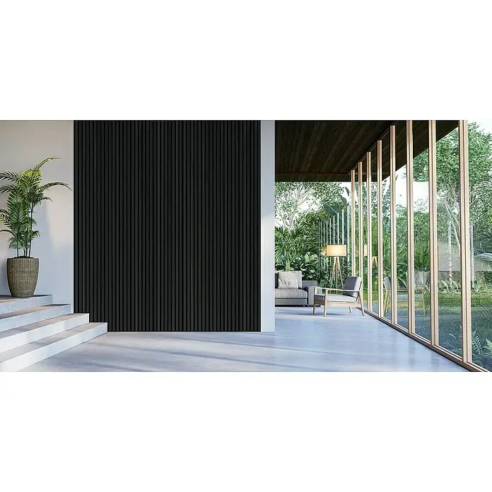 FibroTech Akustikpaneel Proff - Schwarz, Eiche, 3.000 x 605 x 22 mm - Innenarchitektur mit Betonboden, schwarzer Akzentwand und Treppenaufgang mit Topfpflanze. Helle Sitzgruppe mit Natur dahinter.