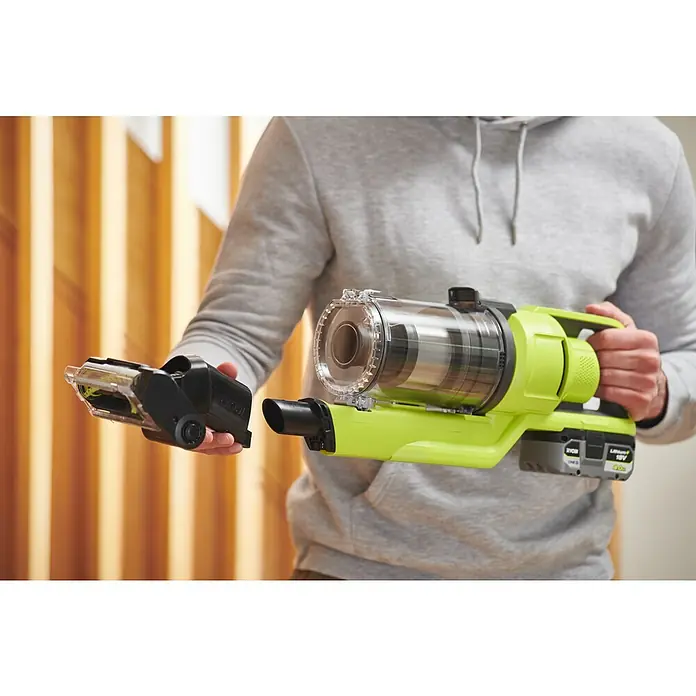 Ryobi ONE+ Maschinenpaket - Akku-Staubsauger RSV18-0 + gratis Starter-Kit - Ein Akku-Staubsauger der Marke Ryobi wird mit einem Zubehörteil in der Hand gehalten. Der Staubsauger ist grün und schwarz.