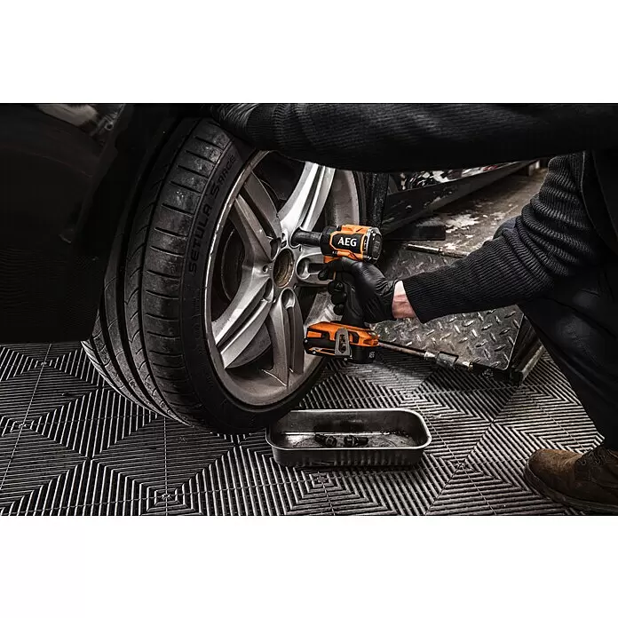 AEG Pro 18V Akku-Schlagschrauber BSS18S12BL2-0 - 18 V, Ohne Akku, 280 Nm - Eine Person benutzt einen orange-schwarzen AEG Schlagschrauber, um Radmuttern an einem Autorad zu lösen.