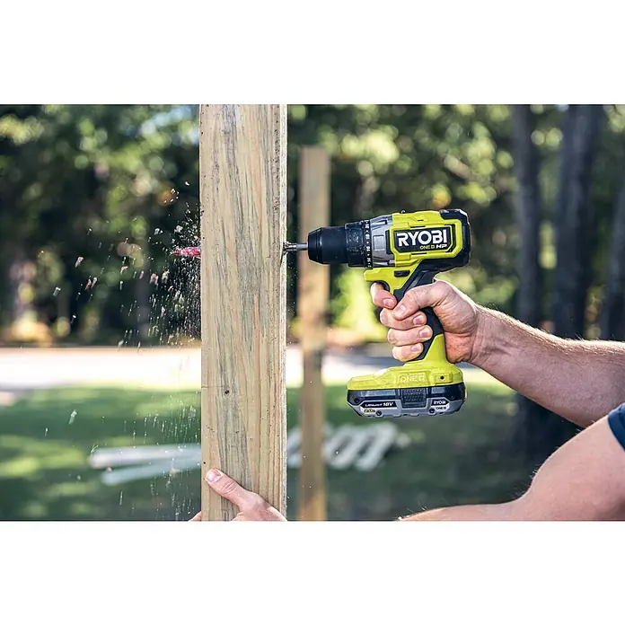 Ryobi ONE+HP Akku-Bohrschrauber RDD18X-0 - 18 V, Ohne Akku, 95 Nm - Nahaufnahme eines Ryobi ONE+ HP Akku-Bohrers, der in ein Holzstück bohrt, wobei Holzspäne herumfliegen.