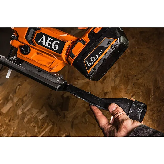 AEG Pro 18V Akku-Stichsäge BST 18X2 - 18 V, Ohne Akku, Leerlaufhubzahl: 0 /min - 3.000 /min - Nahaufnahme einer AEG Stichsäge mit aufgesetztem Staubsaugeraufsatz, die von einer Hand gehalten wird. Das Elektrowerkzeug ist orange und schwarz.