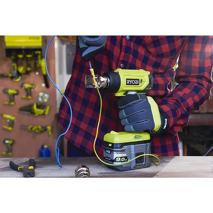 Ryobi ONE+ Akku-Heißluftgebläse R18HG-0 - 0 °C - 470 °C, Ohne Akku - Nahaufnahme eines Ryobi Heißluftgebläses mit Akku, das von einer Person in einem rot-karierten Hemd gehalten wird.