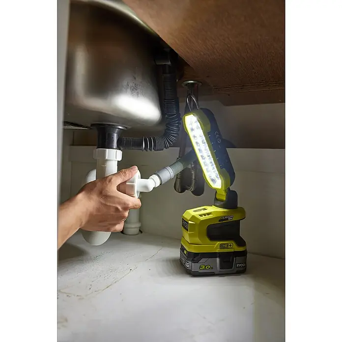 Ryobi ONE+ LED-Arbeitsleuchte R18ALP-0 - 18 V, Li-Ionen, Ohne Akku, 900 lm - Eine Ryobi ONE+ Akku-Arbeitsleuchte beleuchtet die Reparatur eines Spülbeckenabflusses und sorgt für gute Sicht bei der Arbeit.