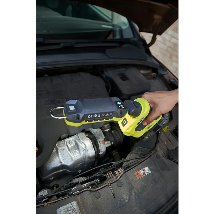 Ryobi ONE+ LED-Arbeitsleuchte R18ALP-0 - 18 V, Li-Ionen, Ohne Akku, 900 lm - Nahaufnahme eines Ryobi Akku-Arbeitsstrahlers, der unter der Motorhaube eines Autos verwendet wird.