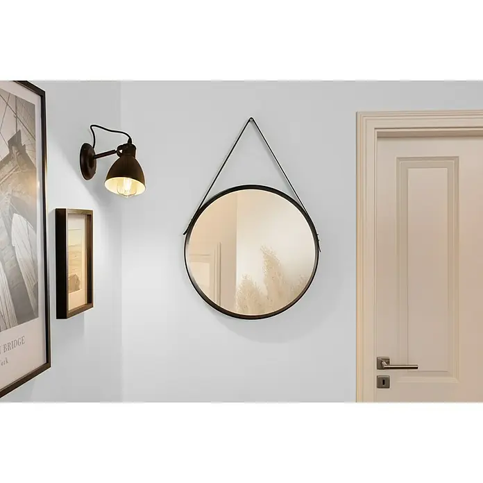 swingcolor Soft Colors Wandfarbe - Smoke, Matt, 5 l - Wandansicht mit einem runden Spiegel mit schwarzem Rahmen, einer Wandleuchte und einem gerahmten Bild, die eine stilvolle und einladende Atmosphäre schaffen.