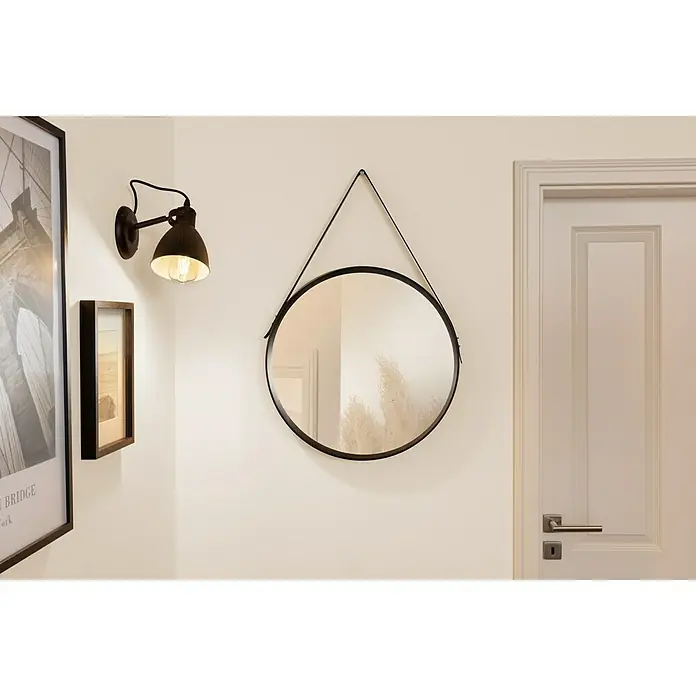 swingcolor Soft Colors Wandfarbe - Amber, Matt, 5 l - An der Wand hängt ein runder Spiegel mit Lederriemen, neben einer Lampe und einem Türrahmen. Elegantes Interior-Design.