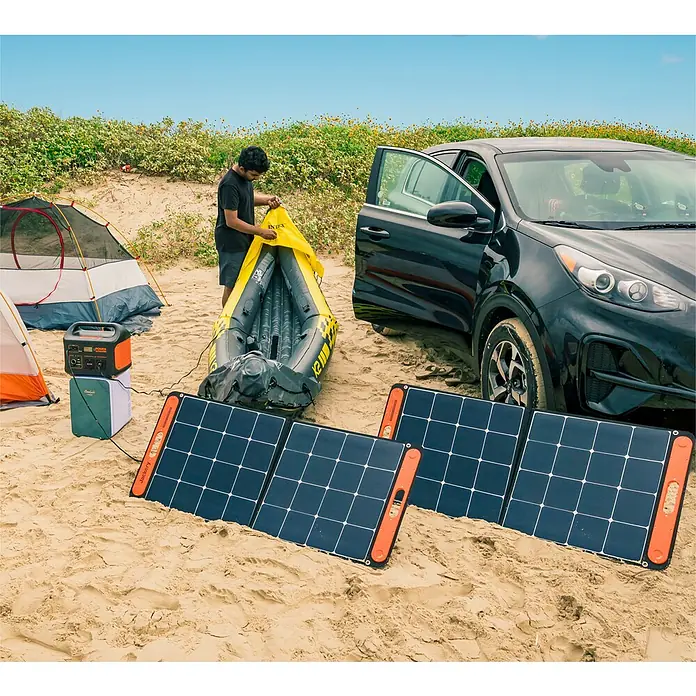 Jackery Colector luz solar Saga - 100 W, 122 x 53,5 cm - Configuración de un sistema solar de camping en la playa con una central eléctrica portátil y paneles solares.