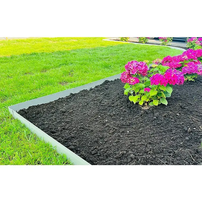 Recal Rasenkante Recal - 1.100 x 1,6 x 100 mm, Silber, Metall - Ein Gartenbeet mit üppiger Erde und leuchtend pinkfarbenen Hortensien, umrandet von einer grauen Beetbegrenzung, eingebettet in grünen Rasen.