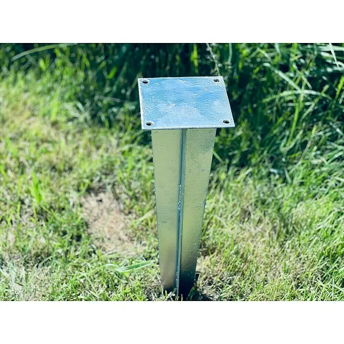 Recal Bodenanker - Passend für: Recal Zaunpfosten - Nahaufnahme einer silberfarbenen Metallpfostenhalterung im Gras, die Stabilität und Befestigung im Freien ermöglicht.