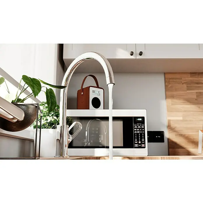 Grohe Start Loop Spültischarmatur - Chrom, Glänzend - Nahaufnahme eines modernen Küchendetails mit einem glänzenden Wasserhahn, Zimmerpflanzen und einer Mikrowelle, die eine elegante und funktionale Küchengestaltung zeigt.