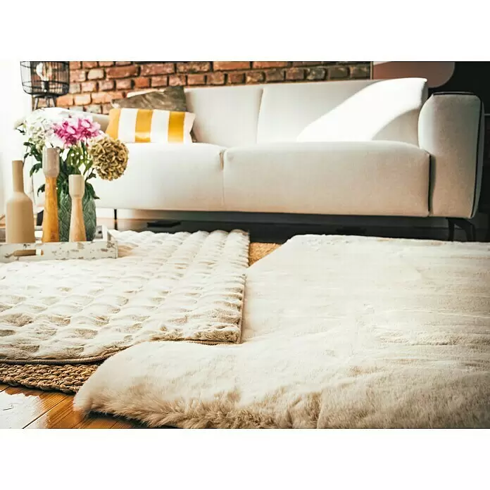 Alfombra de pelo largo Harmony - Beige, 170 x 120 cm, 100% Poliéster - Alfombras cremas suaves y texturizadas superpuestas sobre suelo de madera en sala de estar con sofá.