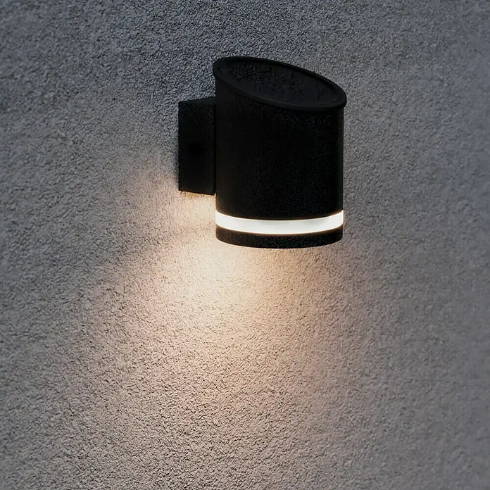 BAUHAUS LED-Solar-AußenwandleuchteAnthrazit, 12 x 9 x 12,5 cm - Schwarze Wandleuchte mit Lichtschein an einer strukturierten Wand.