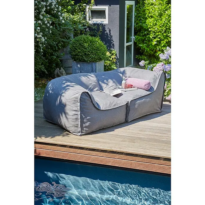 Loungemöbel-Set modular - 2 -tlg., Olefin, 2 Ecken, Grau - Graues Outdoor-Sofa auf einer Holzterrasse neben einem Pool. Eine stilvolle und bequeme Sitzgelegenheit für den Garten oder die Terrasse.