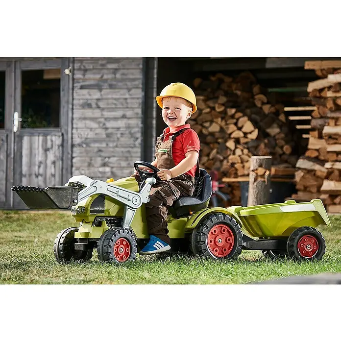Casco de protección Kids - Amarillo - Un niño pequeño conduce un tractor de pedal Claas verde con pala y remolque, perfecto para los niños que les gusta jugar al aire libre.
