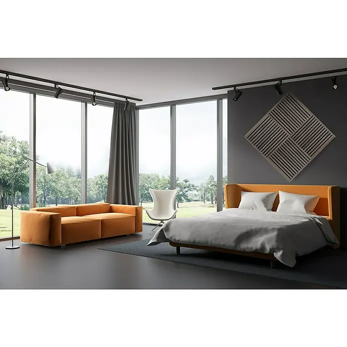 FibroTech Akustikpaneel SQUARE - Walnut, 520 x 520 x 22 mm - Helles Schlafzimmer mit Doppelbett, orangefarbenem Sofa, Designstuhl und großen Fenstern mit Blick auf die Natur. Akustikplatte an der Wand.