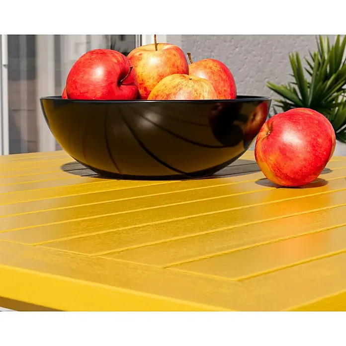 swingcolor Buntlack Kunstharz für Außen - Rapsgelb, Seidenmatt, 125 ml, Lösemittelbasiert - Eine Nahaufnahme von Äpfeln in einer schwarzen Schale auf einem gelben Tisch. Die Äpfel sind rot und gelb und sehen frisch und saftig aus.