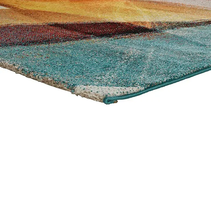 Alfombra de pelo corto Leire - Multicolor, 230 x 160 cm - Primer plano de una alfombra con un patrón abstracto en azules, rojos y amarillos. El borde está rematado con una banda turquesa.
