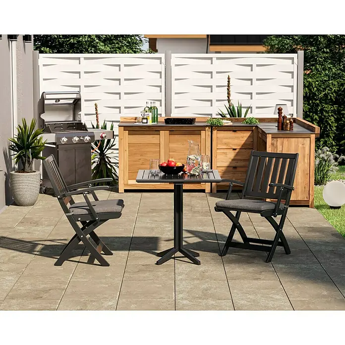 swingcolor Buntlack Kunstharz für Außen - Anthrazitgrau, Seidenmatt, 375 ml, Lösemittelbasiert - Gartenszene mit Esstisch und zwei Klappstühlen mit grauen Kissen, Grill und Outdoor-Küche im Hintergrund. Entspannung im Freien.