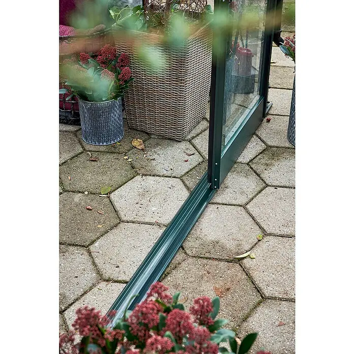 Halls Gewächshaus Garden Room - Außenmaß inkl. Dachüberstand (B x T): 390 x 389 cm, Material Seitenwand: Glas, 3 mm, Schwarz - Nahaufnahme eines Gewächshausrahmens mit Pflanzen und Pflastersteinen im Hintergrund.
