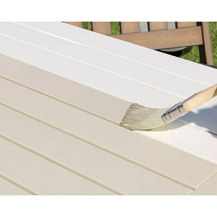 swingcolor Buntlack Kunstharz für Außen - Cremeweiß, Seidenmatt, 750 ml, Lösemittelbasiert - Ein Pinsel, der cremefarbene Farbe auf eine hölzerne Terrassendiele aufträgt, um die Schönheit und den Schutz des Holzes zu gewährleisten.