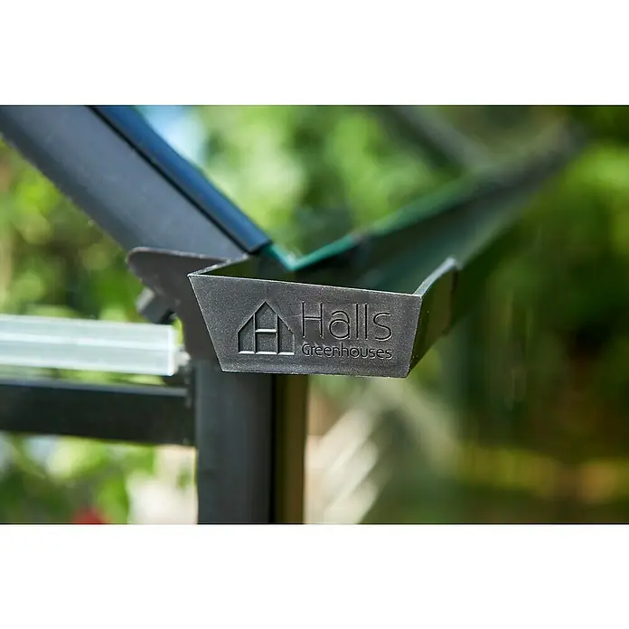 Halls Gewächshaus Qube 610 - Außenmaß inkl. Dachüberstand (B x T): 198 x 321 cm, Material Seitenwand: Glas, 3 mm, Schwarz - Nahaufnahme einer Dachrinne eines Halls Gewächshauses mit eingeprägtem Logo, das die Marke und Qualität des Gewächshauses hervorhebt.