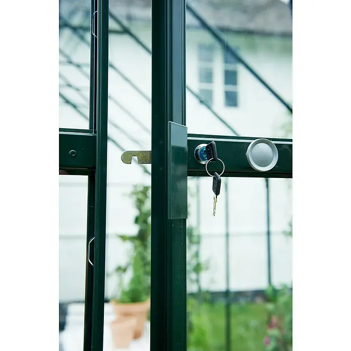 Halls Gewächshaus Magnum 128 - Außenmaß inkl. Dachüberstand (B x T): 257 x 384 cm, Material Seitenwand: Glas, 3 mm, Grün, Sicherheitsglas - Nahaufnahme eines grünen Gewächshaustürschlosses mit Schlüsseln. Das Schloss sichert den Zugang zum Gewächshaus.